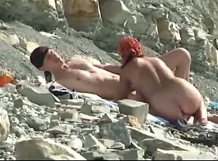 Husband films his wife at the beach